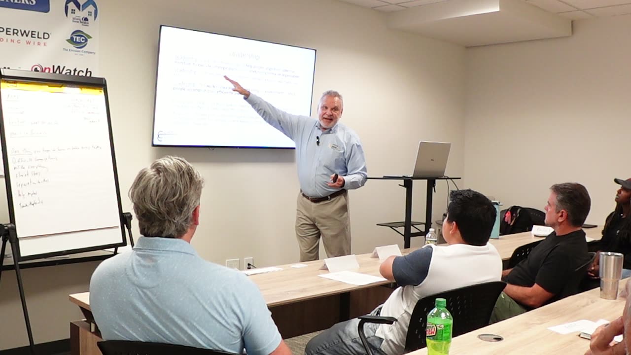Bobby Mink pointing to a slide while teaching